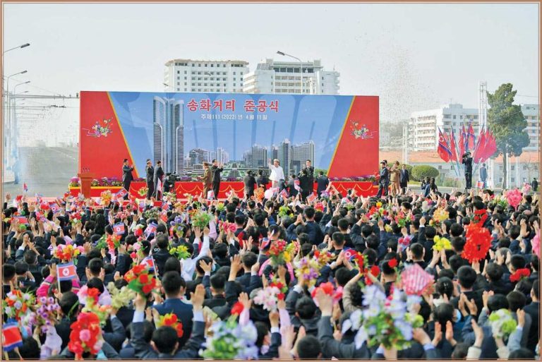 The respected Comrade Kim Jong Un warmly waved back to the cheering crowds, wishing the owners of the new street and new houses a happy life.