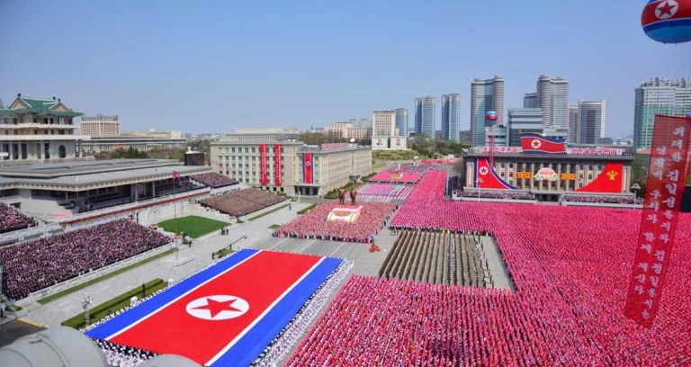 The public procession started with the column of citizens holding a large flag of the DPRK.