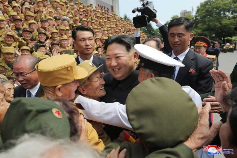 Kim Jong Un having a photograph taken with the participants in the Eighth National Conference of War Veterans