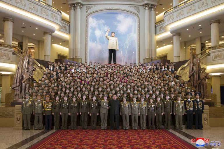 Kim Jong Un having a photograph taken with the lecturers engaged in administration of revolutionary relics associated with the victorious war